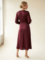 deep burgundy satin-touch wrap midi dress with subtle luminous sheen — back view